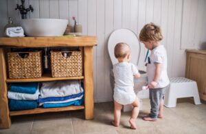 two-small-children-looking-at-toilet